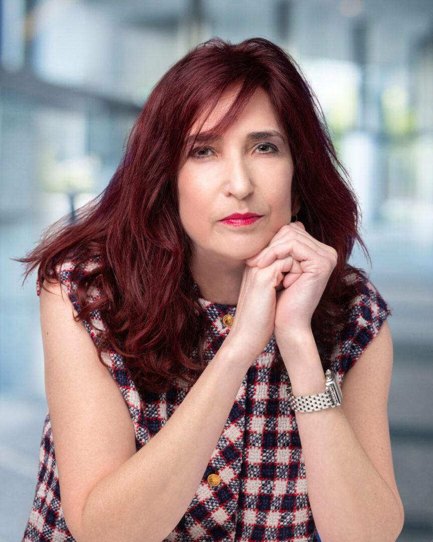 A woman with red hair and a plaid shirt